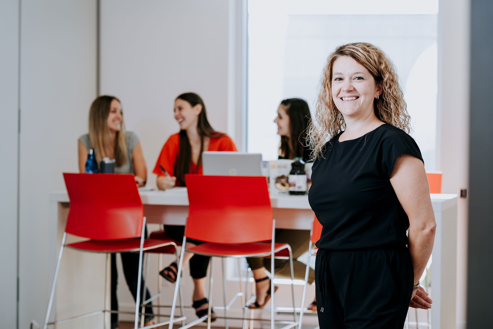 Employee smiling in front of conference room
