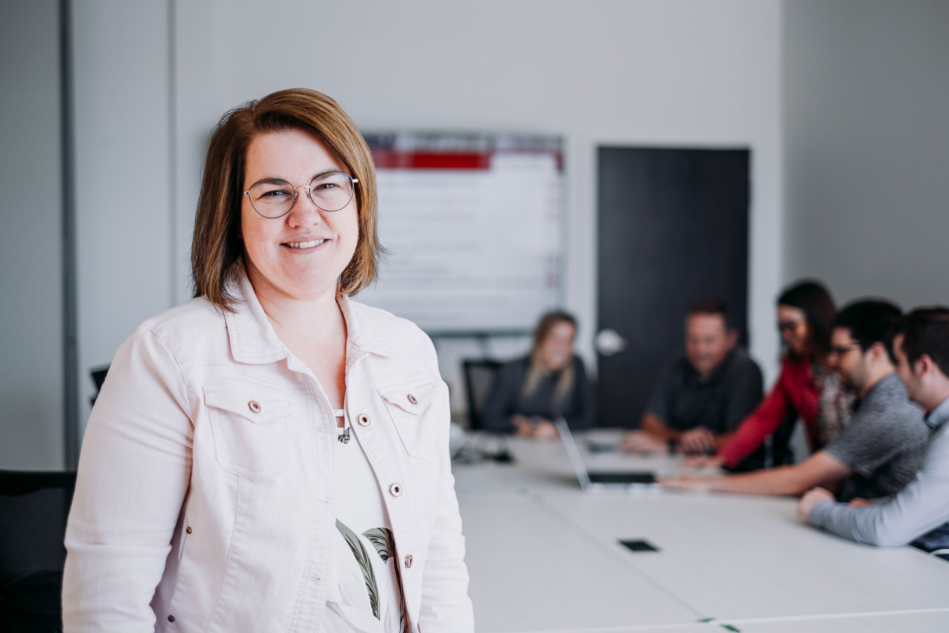 Fruit d'Or's smiling employee in front of a conference room