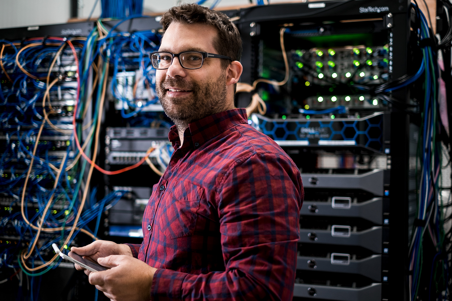 IT Technician standing beside servers